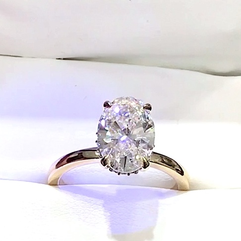 18kt Yellow Gold Engagement Ring with 3.0 carat lab diamond at the center (Color: E | Clarity: VVS2 | Oval Cut) and natural E / VVS grade Setting Diamonds. Hidden halo Solitaire Setting.